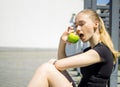 Beautiful athletic blonde woman eating a green apple after workout Royalty Free Stock Photo