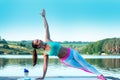 Beautiful athletic girl does yoga on the background of beautiful nature. Vasisthasana - Side Plank yoga pose