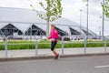 beautiful athletic girl runs at a city sports event, race, against the background of a new stadium