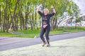 beautiful athletic girl runs at a city sports event, race, against the background of a new stadium