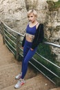 beautiful athletic girl in stylish sportswear posing on cliff near railings Royalty Free Stock Photo