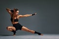 beautiful and athletic girl in a top and shorts and black socks posing in studia on a gray background Royalty Free Stock Photo