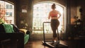 Beautiful Athletic Plus Size Body Positive Sports Woman Running on a Treadmill at Her Home Gym Royalty Free Stock Photo