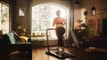 Beautiful Athletic Plus Size Body Positive Sports Woman Running on a Treadmill at Her Home Gym Royalty Free Stock Photo