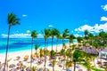 Beautiful atlantic tropical beach with palms, umbrellas and parasailing balloon. Aerial view of Bavaro beach Punta Cana tropical