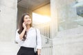 Beautiful Attractive Asian Business woman smile talking with customer in smartphone outside office to get requirement Royalty Free Stock Photo