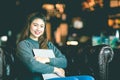 Beautiful Attractive Asian Business woman wearing sweater smile and hug computer laptop on sofa in coffee shop Royalty Free Stock Photo