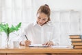 Beautiful Attractive Asian woman holding pencil thinking and writing data or business planning Royalty Free Stock Photo