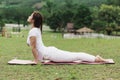 Beautiful Attractive Asian woman sitting on yoga mat practice Cobra Pose with yoga meditation relax and refresh health on green gr Royalty Free Stock Photo