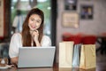 Beautiful Attractive Asian woman using computer laptop shopping online with shopping bags Royalty Free Stock Photo