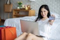 Beautiful Attractive Asian young woman lying on bed and using computer laptop for using social media and shopping online Royalty Free Stock Photo