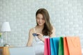 Beautiful Attractive Asian young woman lying on bed and using computer laptop for using social media and shopping online holding c Royalty Free Stock Photo