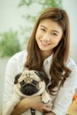 Beautiful Attractive Asian young woman playing with her dog and smile with dog pug breed Royalty Free Stock Photo