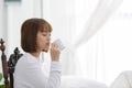 Beautiful Attractive Asian young woman sitting on wooden chair and relax with coffee after wake up in the morning Royalty Free Stock Photo