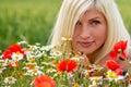 Beautiful, attractive, blonde woman portrait with meadow flowers. Soft focus