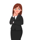 Beautiful attractive businesswoman thinking while touching her finger on face with thoughtful expression while looking up. Royalty Free Stock Photo