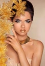 Beautiful Attractive Girl With Golden Flowers. Beauty Model Woman Face. Perfect Skin. Professional Make-up. Makeup. Royalty Free Stock Photo