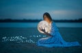 Beautiful attractive girl on a night beach with sand and stars hugs the moon, Artistic Photography Royalty Free Stock Photo