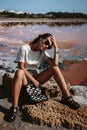 Beautiful, attractive and stylish young woman is sitting and posing on the rocks. Countryside landscape, nature, water and stones Royalty Free Stock Photo