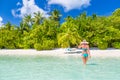 Beautiful attractive woman in bikini and hat walking on beach wooden jetty and luxury tropical sea view, luxury lifestyle Royalty Free Stock Photo