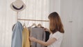 Beautiful attractive young Asian woman choosing her fashion outfit clothes in closet at home or store. Royalty Free Stock Photo