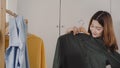 Beautiful attractive young Asian woman choosing her fashion outfit clothes in closet at home or store. Girl think what to wear Royalty Free Stock Photo