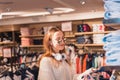 Beautiful young woman  chooses clothes at fashion and clothes Shop Royalty Free Stock Photo