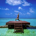 Beautiful attractive young woman in bikini exercising yoga on the Maldives beach. Luxury travel. Tourism Royalty Free Stock Photo