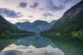 beautiful austrian mountain lake plansee with reflection of the mountains and clouds