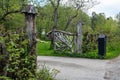 Beautiful authentic wooden fence with entrance gate around the village house. Metal black mailbox near the road. Landscape garden