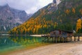 Beautiful autumn alpine landscape, spectacular old wooden dock house with pier on Braies lake, Dolomites, Italy