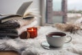 Beautiful autumn composition with burning candle and cup of tea on window sill Royalty Free Stock Photo