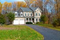 Beautiful autumn exterior of the house. Yard with green grass and path leading to the garage Royalty Free Stock Photo