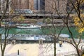 A beautiful autumn landscape along the Chicago River with yellow autumn trees, boats on the water and skyscrapers and hotels