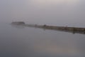 Beautiful autumn landscape with a bridge, stone pier, water and mist Royalty Free Stock Photo