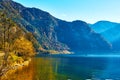 Beautiful autumn landscape of Hallstatt lake with boat and trees at sunny day in Austrian Alps, Salzkammergut region. Royalty Free Stock Photo