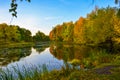 Beautiful autumn landscape. Lake, yellow and red trees by the lake. Reflection in water. Blue sky. Sunny autumn day Royalty Free Stock Photo