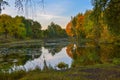 Beautiful autumn landscape. Lake, yellow and red trees by the lake. Reflection in water. Blue sky. Sunny autumn day Royalty Free Stock Photo