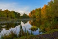 Beautiful autumn landscape. Lake, yellow and red trees by the lake. Reflection in water. Blue sky. Sunny autumn day Royalty Free Stock Photo