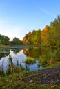 Beautiful autumn landscape. Lake, yellow and red trees by the lake. Reflection in water. Blue sky. Sunny autumn day Royalty Free Stock Photo