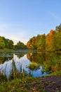 Beautiful autumn landscape. Lake, yellow and red trees by the lake. Reflection in water. Blue sky. Sunny autumn day Royalty Free Stock Photo