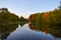 Beautiful autumn landscape. Lake, yellow and red trees by the lake. Reflection in water. Blue sky. Sunny autumn day Royalty Free Stock Photo