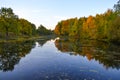 Beautiful autumn landscape. Lake, yellow and red trees by the lake. Reflection in water. Blue sky. Sunny autumn day Royalty Free Stock Photo