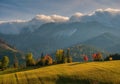 Beautiful autumn landscape in the mountains. Clouds illuminated by the morning sun floating low over the valley. Royalty Free Stock Photo