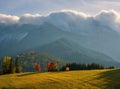 Beautiful autumn landscape in the mountains. Clouds illuminated by the morning sun floating low over the valley. Royalty Free Stock Photo