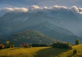 Beautiful autumn landscape in the mountains. Clouds illuminated by the morning sun floating low over the valley. Royalty Free Stock Photo