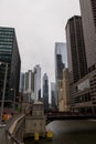 a beautiful autumn landscape with people walking and cars driving over the Monroe Street bridge over the Chicago River