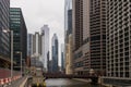 a beautiful autumn landscape with people walking over the Monroe Street bridge over the Chicago River and skyscrapers