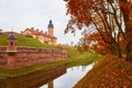 Beautiful autumn landscape. Yellow and red trees shed their foliage. View of the Nesvizh Castle in Belarus