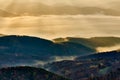 The first rays of the sun in the autumn mountain landscape at dawn. Illuminating valley through the fog. Vrsatec, Slovakia. Royalty Free Stock Photo